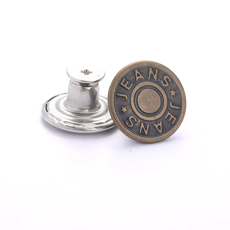 A round, bronze button with the word JEANS engraved on it, next to a silver button repair kit component.