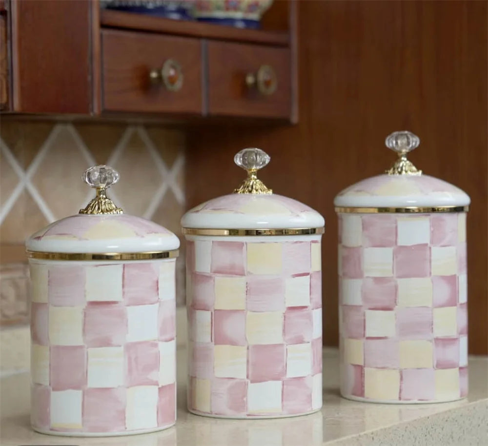 Three decorative porcelain storage jars with a pink and cream checkerboard pattern.