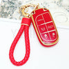 A red TPU car key fob cover with a keyring attached to a red braided cord.