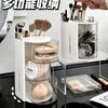 A clear acrylic organizer holds various makeup brushes and hair accessories in rotating compartments.