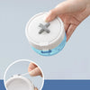 A hand is holding an open portable denture case with a cleaning brush storage compartment.