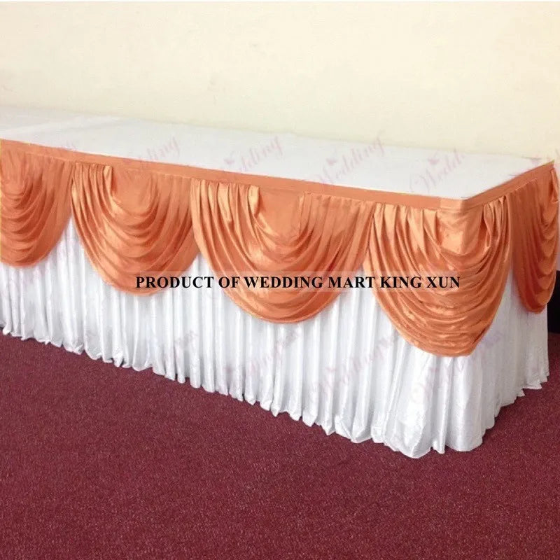 Elegant ice silk table skirt with matching top swag in white and orange tones.