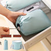 A hand is shown expanding a light blue collapsible foot bath tub with an insulated liner and travel storage bag.