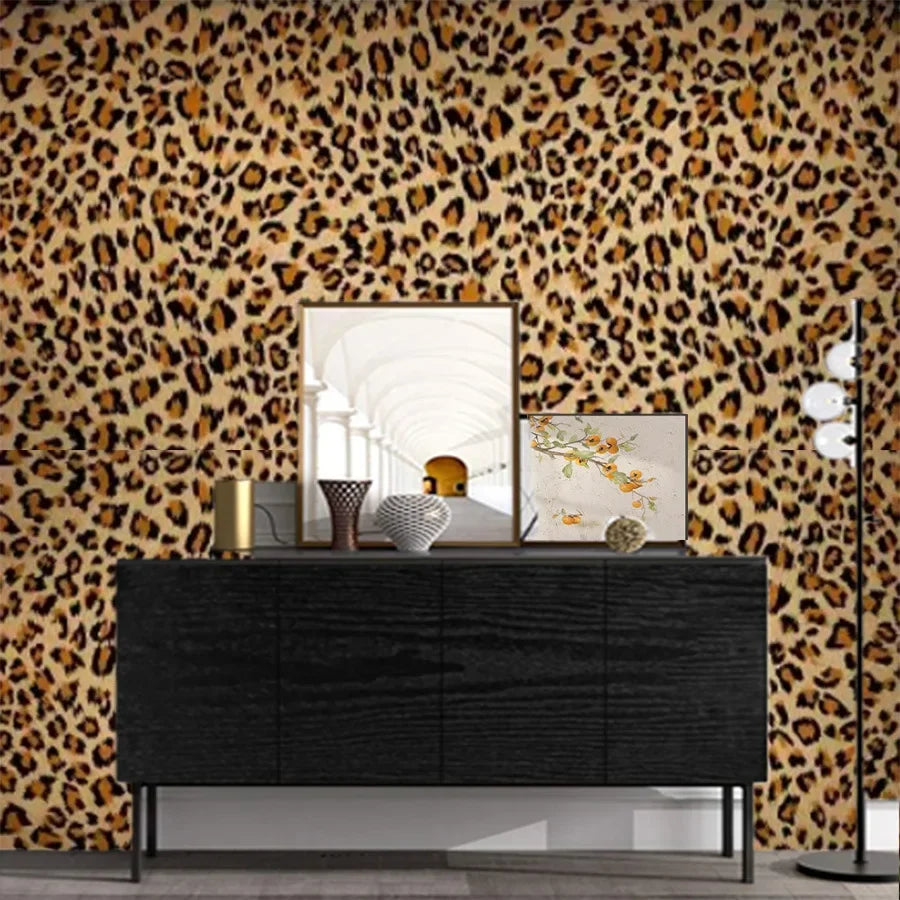 A dark dresser with decorative items set against a leopard print wallpaper background.
