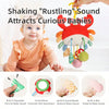 A baby is shown interacting with a hanging rattle and teether toy designed to attract curious babies.