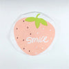 A pink strawberry design with a green leaf and the word smile on a clear waterproof shower cap.