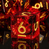 A close-up of red resin polyhedral dice set reflecting on a dark surface.