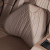A tan memory foam lumbar support and neck pillow set placed on a car seat cushion.