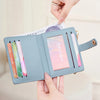 A light blue bi-fold credit card wallet is shown being held by hands, displaying its interior and exterior features.