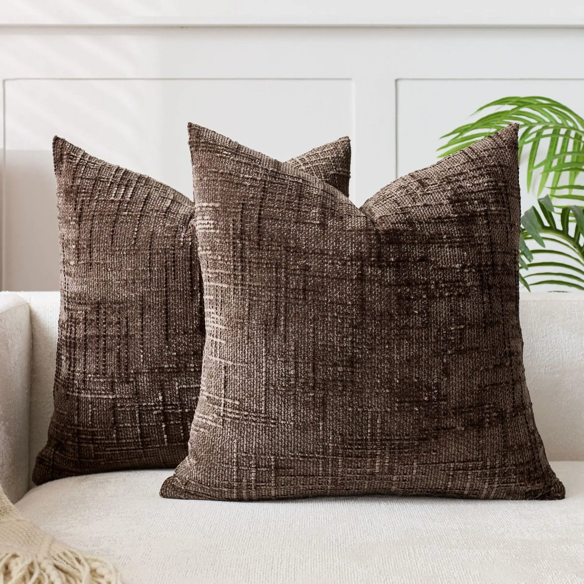 A dark brown handwoven chenille texture cushion cover resting on a light-colored sofa.