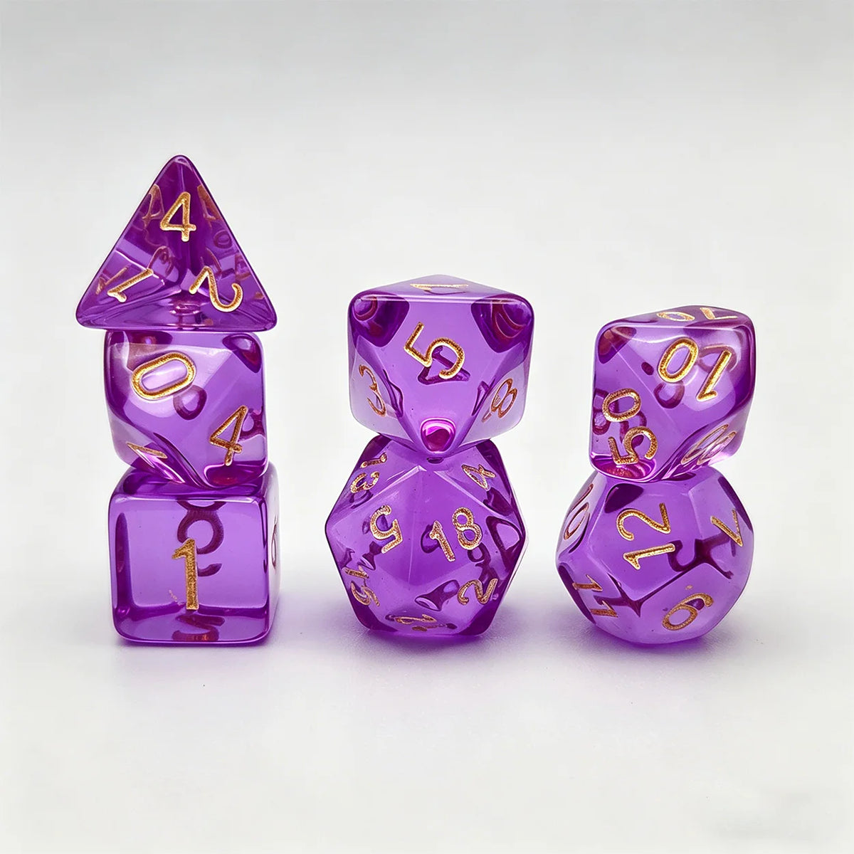 A set of seven translucent purple acrylic polyhedral dice, including a tetrahedron and dodecahedron.