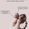 A hand is holding a silicone pacifier clip with a teether made from original wood.