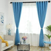 Light blue magnetic curtain clips on a window with sheer white curtains and blue fabric drapery.