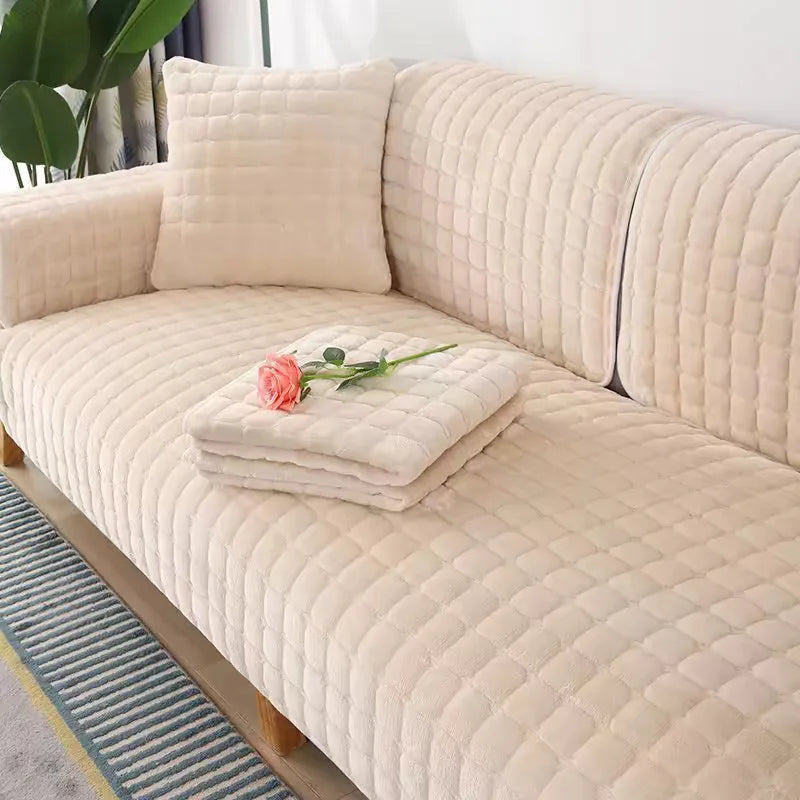 A beige quilted velvet sofa cushion cover on a light wood frame with a striped rug.