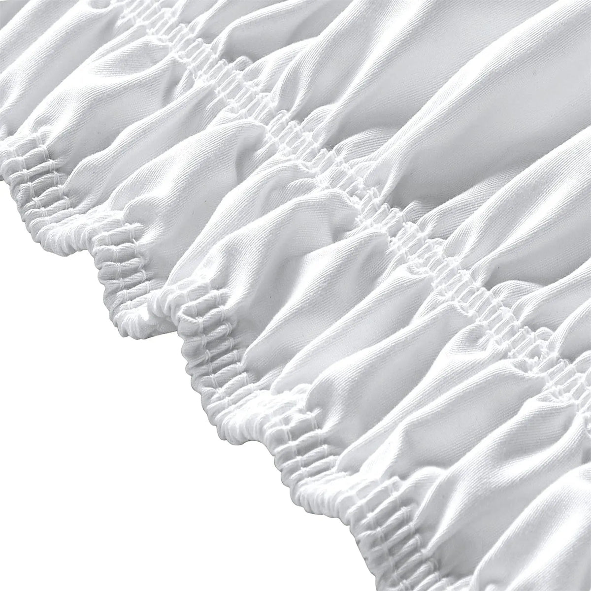 Close-up of a white adjustable wrap-around bed skirt featuring elegant ruffles and gathered fabric.