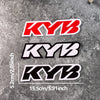 Three black and white KYB motocross motorcycle fork stickers displayed on a gray textured surface.