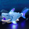 A blue shark toy with glowing lights is shown against a dark blue background.