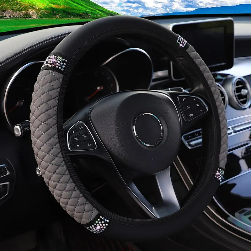 A black steering wheel with a diamond-patterned faux leather cover and accents is visible inside a car interior.