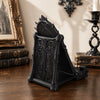 A black gothic skull phone stand featuring intricate thorn details, displayed on a wooden surface.