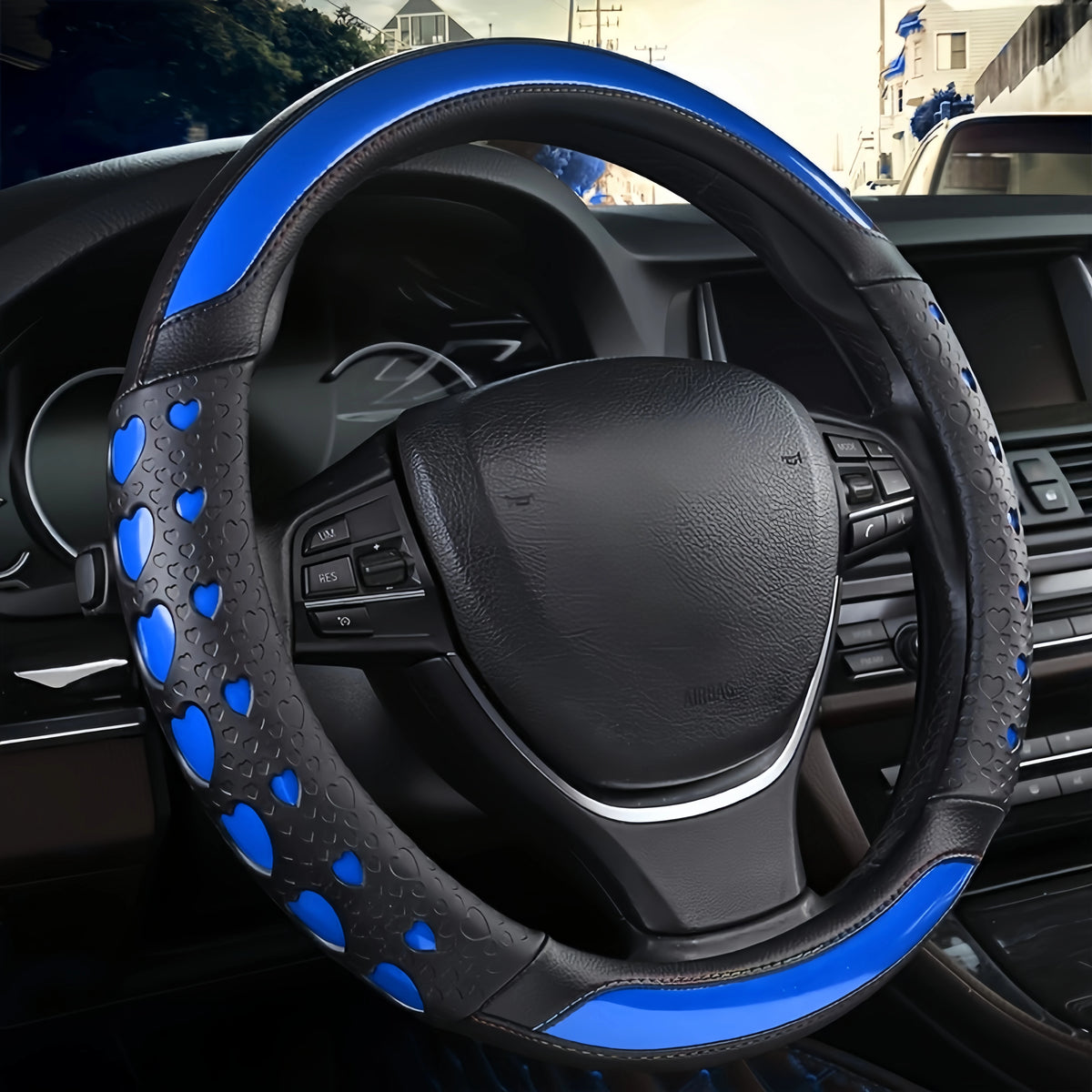 A close-up view of a black steering wheel with blue heart-shaped accents and leather wrapping.