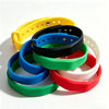 A stack of colorful silicone wristbands in yellow, black, blue, green, red, and white for access control.