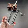 A miniature metal katana replica with a wooden hilt and a chain attached, displayed next to an illustration of a character.