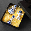A set of three handcrafted astronaut figurine resin spaceman desk decor figures displayed in a black box with yellow lighting