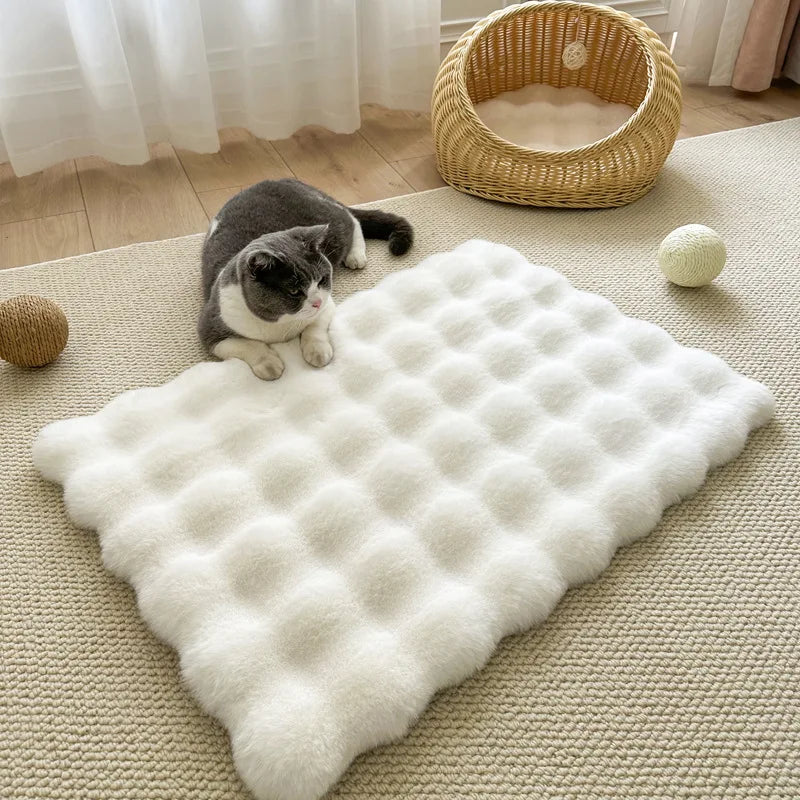 Ein flauschiges weißes Tiermatten liegt auf einem hellbeigen Teppich mit einer Katze und einem geflochtenen Korb im Hintergru