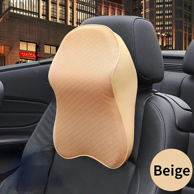 A beige 3D memory foam car seat headrest pillow placed on a black car seat.