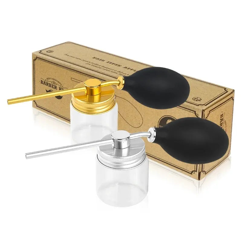 A gold-top glass bottle and a black silicone nozzle are shown next to a cardboard box for a refillable hair fiber powder spra