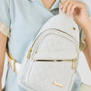 A light gray quilted crossbody sling bag is shown being carried by a person wearing a light blue shirt.