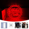 An LED neon sign shaped like a Coca-Cola bottle with the word Nuka glowing red against a dark background.