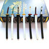 A set of five Demon Slayer mini katana replicas with decorative hilts displayed in front of a book.