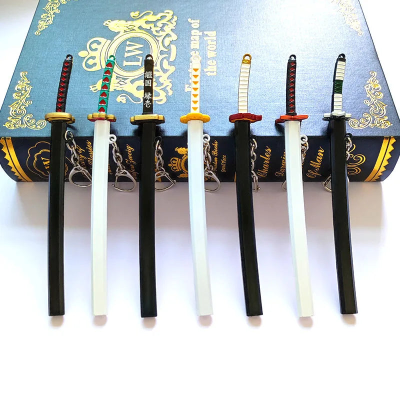 A set of five Demon Slayer mini katana replicas with decorative hilts displayed in front of a book.