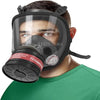 A man wearing a black full face respirator mask with a gas filter canister on his face.
