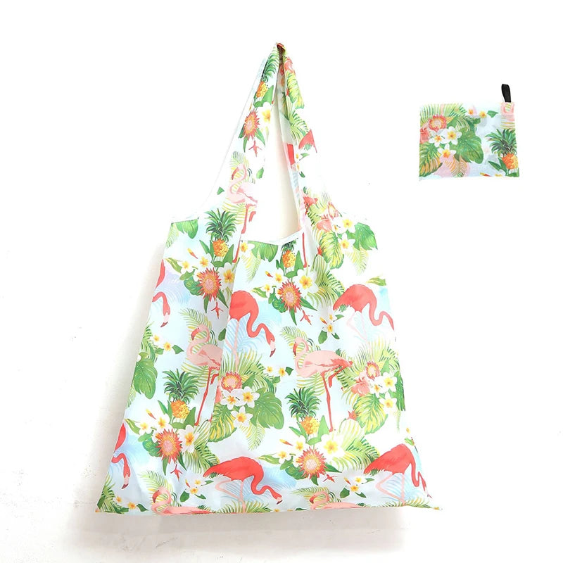 A reusable shopping tote bag featuring a tropical floral print with pink, green, and orange elements.