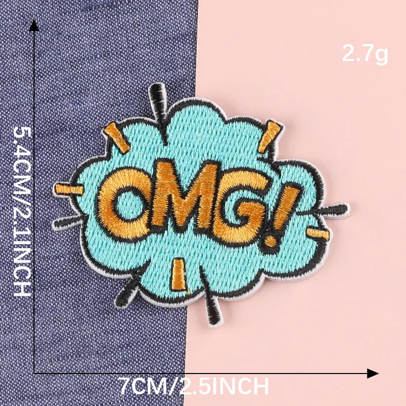 A turquoise embroidered lettering patch shaped like an exclamation mark with the text OMG in gold thread.