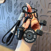 A hand holds a black fitness keychain featuring a 5kg weight and various metal chains.