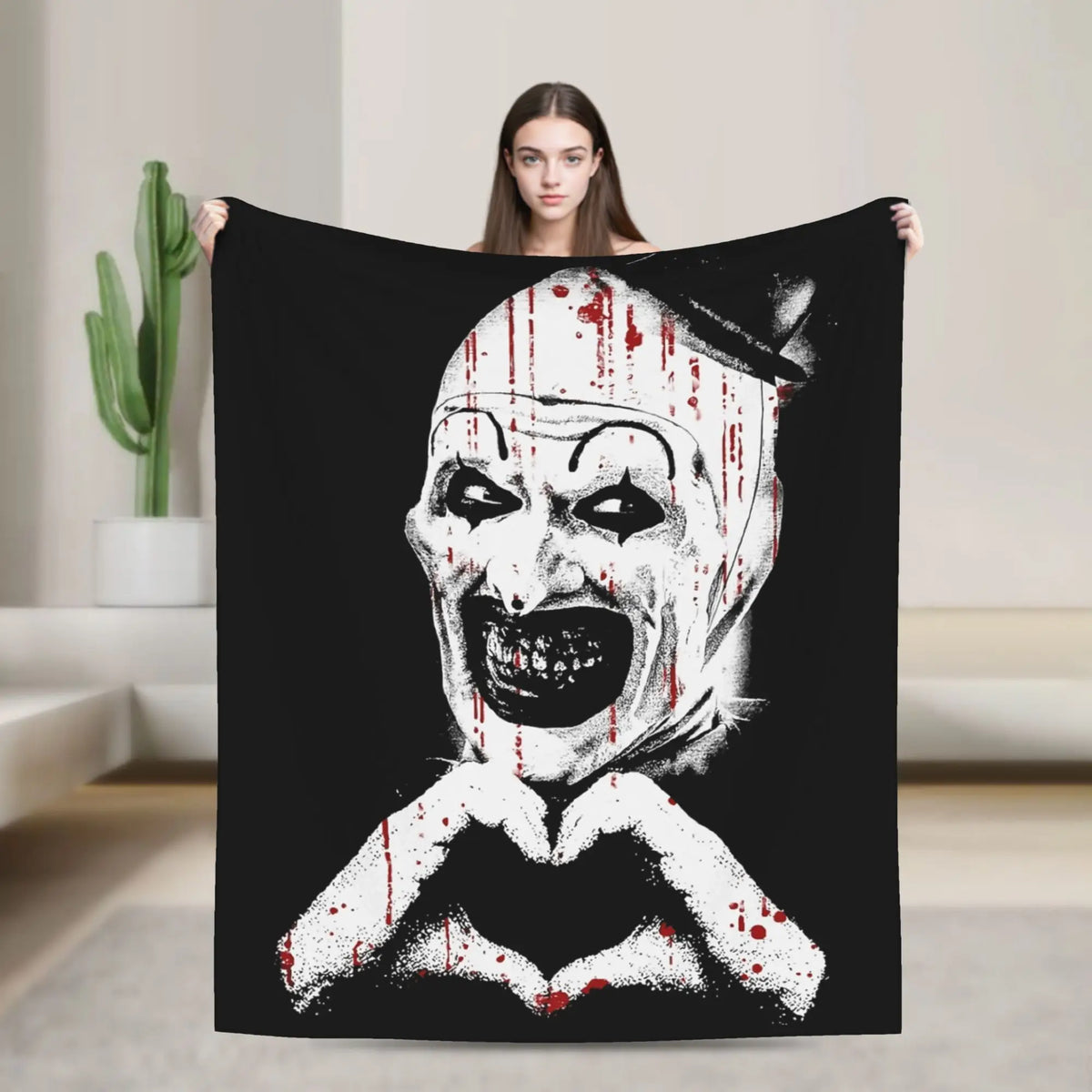 A black throw blanket featuring a distressed white clown face with blood splatters.