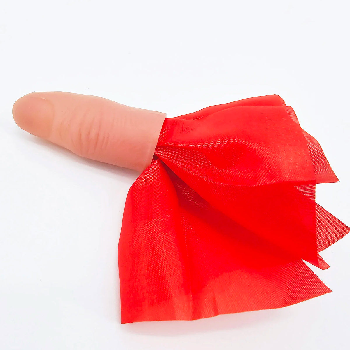 A red silk magic thumb tip with a classic design shown next to a finger.