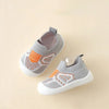 A pair of gray and orange breathable soft-sole baby shoes with a non-slip grip shown from above.