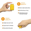 A hand holds a small yellow glass juice bottle with a white lid, demonstrating its premium quality and easy pouring.