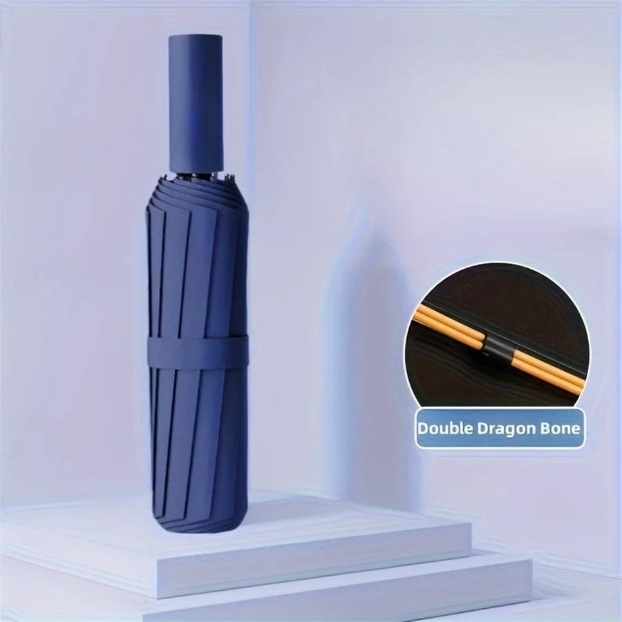 A dark blue Double Dragon Bone folding umbrella standing upright on a white surface.