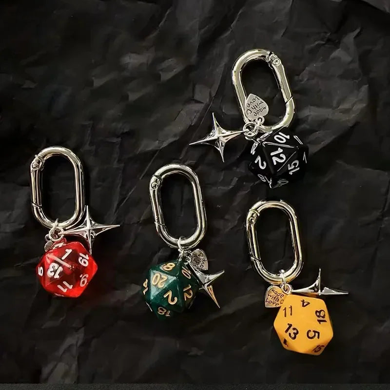 A set of red and green dice keychains with silver D-shaped buckles and star charms on a black background.