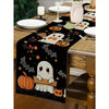 Black Halloween table runner featuring orange pumpkins, bats, and jack-o'-lanterns