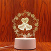 A glowing heart wreath design on a white light base, illuminating a 'I love you' message against a wooden background.