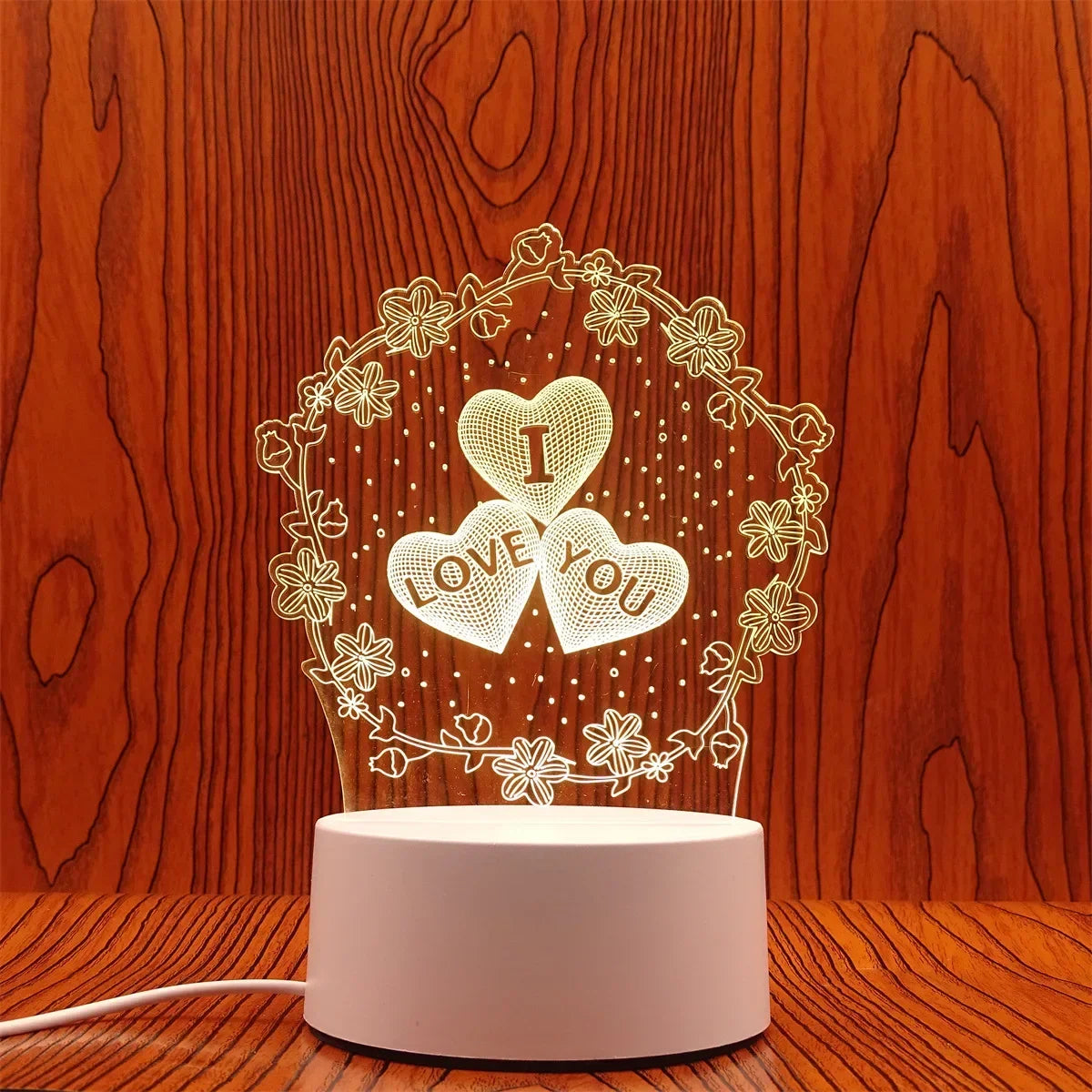 A glowing heart wreath design on a white light base, illuminating a 'I love you' message against a wooden background.