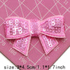 Pink sequin bow patches for DIY crafts shown on a pink cutting mat