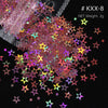 A close-up view of a pile of multi-colored holographic star sequins for resin crafts, with some loose pieces scattered on a d