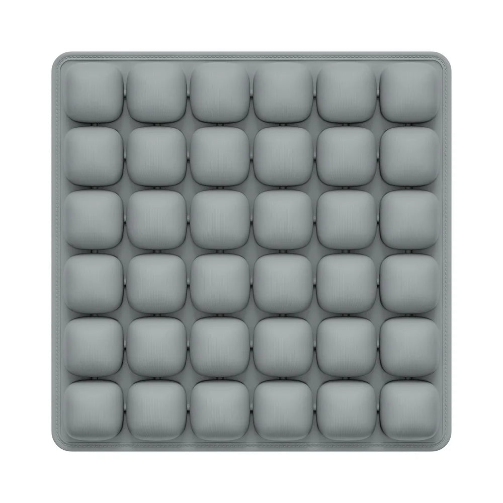 A gray, square seat cushion with multiple individual pockets for adjustable pressure relief.
